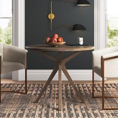 a dining room table with two chairs and a bowl of fruit on the table next to it