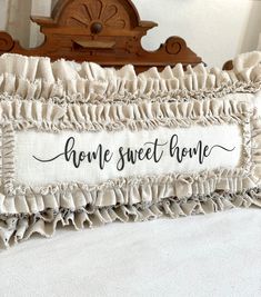 a pillow that has the words home sweet home written on it and ruffled edges