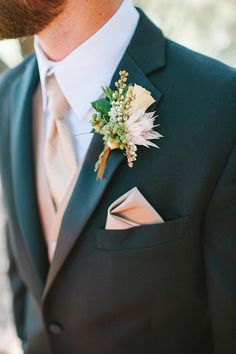 a man in a suit and tie with a boutonniere on his lapel