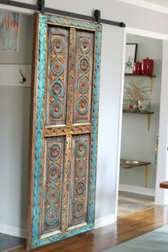 an old wooden door is painted blue and gold with intricate designs on the front panel