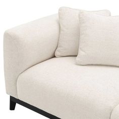 a white couch with two pillows on the back and one pillow that is folded over