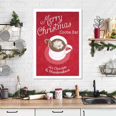 a christmas poster hanging on the wall above a kitchen counter with dishes and utensils