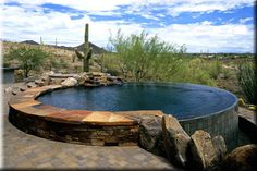 a large pool surrounded by rocks and cactus