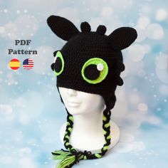 a crocheted hat with green eyes on top of a mannequin head