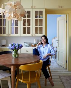 a woman sitting at a table in a kitchen