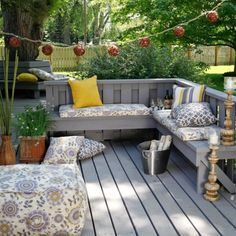 an outdoor seating area with cushions and pillows