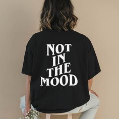 Step into the world of witty humor with our "Not In The Mood" shirt. This funny introvert shirt features clever words on the back, making it a perfect statement piece for introverts and sarcasm lovers alike. Crafted with attention to detail, this trendy shirt is designed to bring a touch of humor to your everyday wardrobe. Available in various sizes and colors, this shirt is made with high-quality materials to ensure comfort and durability. Whether you're looking to express your introverted natu Fun Shirt Ideas, Witty Humor, Not In The Mood, Introvert Humor, Funny Statements, Word Shirts, Introverted, Statement Shirt, Trendy Tee