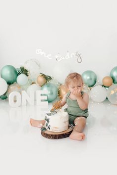 a baby sitting in front of a cake