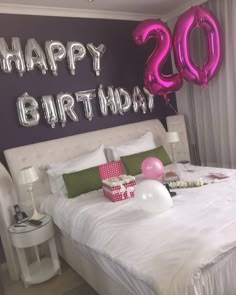 a bedroom decorated with balloons and presents for someone's 30th birthday, while the number 20 is displayed on the wall above the bed