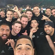 a group of men standing next to each other in front of a crowd at a sporting event