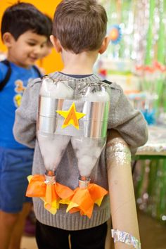 two young boys standing next to each other in front of a table with decorations on it