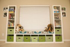 the shelves are filled with toys and other items in green bins next to a window