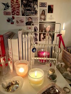 a table topped with candles and pictures next to other items on top of the table