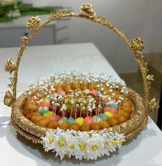 a basket filled with lots of candies and flowers on top of a white table