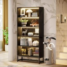 a bookshelf filled with lots of books next to a white vase and lamp