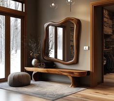 a wooden bench sitting in front of a large mirror on top of a hard wood floor