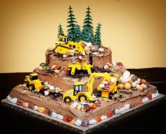 there is a cake made to look like a construction site with trucks and trees on top