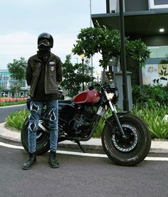 a man is standing next to his motorcycle