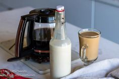 a bottle of milk next to a cup of coffee