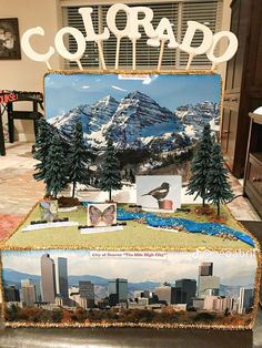 a cake that has pictures on it with the word colorado written in white letters and trees