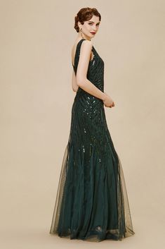 a woman in a long green dress with sequins on the skirt and back