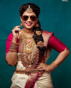 a woman in a pink and white sari with her hands on her hips, posing for