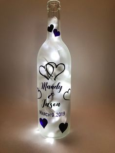 a lighted wine bottle with hearts on it