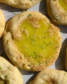 there are many small cookies that have been cut in half and filled with yellow sauce