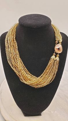 "This is a beautiful golden brown seed bead parure, comprised of clip-on earrings, multi-strand necklace and bracelet. All pieces are marked Japan.  Necklace is :17-1/2\"x1-1/2\" Bracelet is :7-1/2\"x1-1/2\" Earrings are 1\"rnd" Gold Double Strand Bohemian Beads, Brown Beaded Multi-strand Jewelry, Multi-strand Gold Beads Costume Jewelry, Brown Multi-strand Jewelry With Colorful Beads, Gold Multi-strand Jewelry With Spacer Beads, Multi-strand Brown Jewelry With Polished Beads, Gold Double Strand Polished Bead Necklaces, Gold Double Strand Beaded Necklace With Polished Beads, Elegant Multi-strand Gold Beads