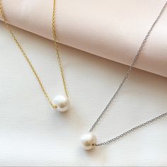 Single white freshwater Pearl necklace in silver and gold. Single Pearl Necklace Tiffany & Co., Cheap White Pearl Pendant Charm Necklace, Classic White Necklace With Delicate Chain, White Classic Necklace With Delicate Chain, Classic Pearl White Necklace With Clavicle Chain, White Pearl Necklace With Delicate Round Pendant, White Pearl Necklace With Delicate Chain And Round Pendant, Classic Pearl Necklace For Gift, Classic Pearl White Pearl Necklace As Gift