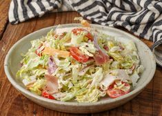 a white bowl filled with salad on top of a wooden table