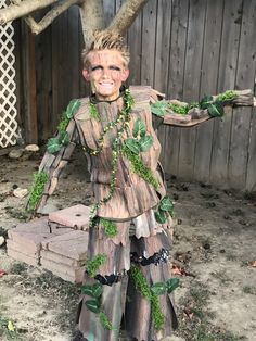 a man dressed as a tree stump with green leaves on it