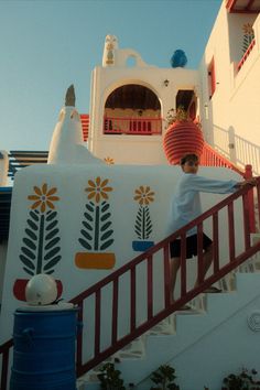 a boy is standing on the stairs in front of a building with flowers painted on it