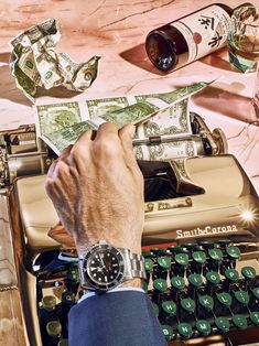 a man is typing on an old - fashioned typewriter with money coming out of it