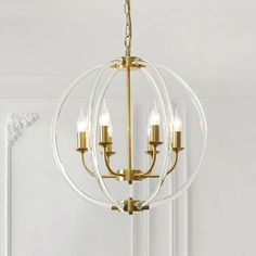 a chandelier with three lights hanging from it's center, in front of a white wall