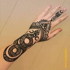 a woman's hand with henna tattoos on it