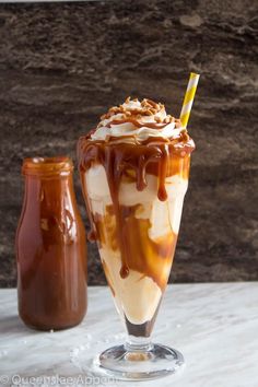 two glasses filled with ice cream and caramel on a table next to each other