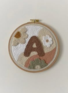 an embroidered wall hanging with the letter a on it