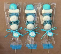 three lollipops wrapped in cellophane and tied with blue ribbon