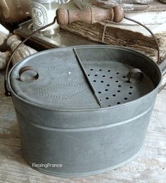 an old metal pot sitting on top of a wooden table