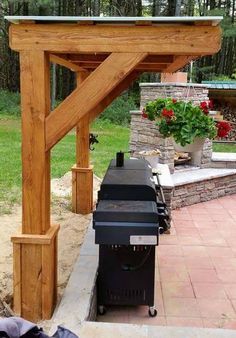 an outdoor bbq grill under a wooden pergolan