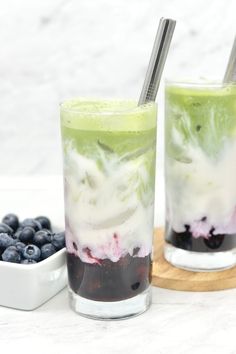 two glasses filled with ice cream and blueberries