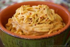 a green bowl filled with noodles and sauce