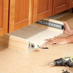 a person is using a drill to fix a drawer