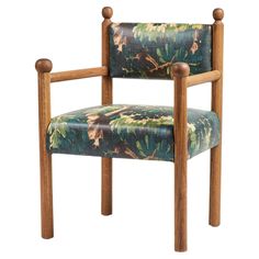 an upholstered chair with wooden legs and floral fabric on the armrests