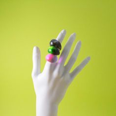 a person's hand with two rings on it and three balls in the middle