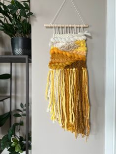 The Juno is the perfect touch of boho for your space. Made with a mixture of fibers including wool, organic cotton, ribbon and rope in shades of yellow and gold in a variety of textures, this piece boasts gorgeous layered fringe and hangs on a wooden dowel. A perfect one-of-a-kind accent piece for your home. Wall hanging is 7" wide by 22" long and is hung on 9" wooden dowel. Layered Fringe, Loom Projects, Weaving Loom Projects, Weaving Wall Hanging, Woven Wall Art, Cotton Ribbon, Weaving Loom, Yarn Wall Hanging, Wall Hanging Diy