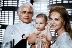 an image of a man and woman holding a baby in front of a movie strip