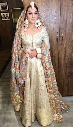 a woman in a wedding dress standing next to a wooden door and wearing a veil