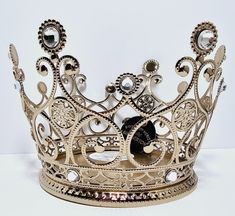 a gold metal crown with jewels on it's sides and a black diamond in the middle